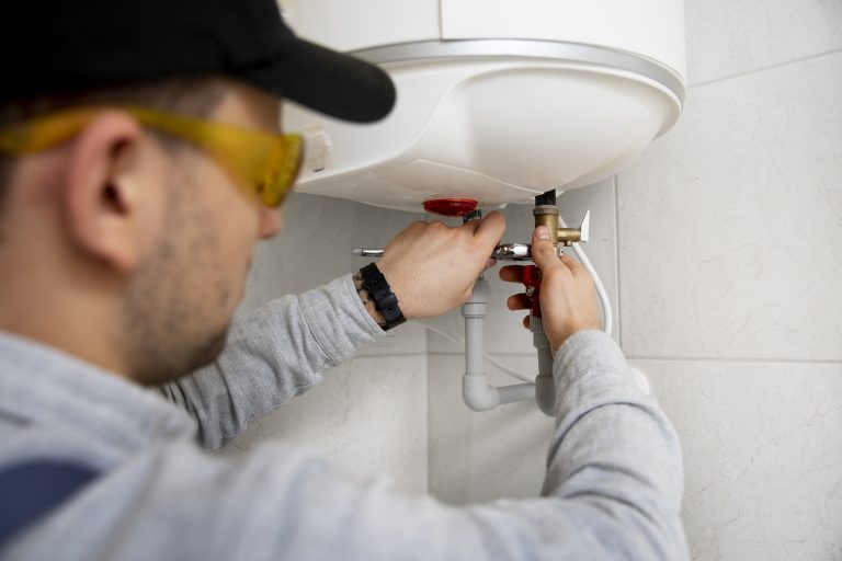 chauffe-eau hitachi avec un technicien réparant un chauffe-eau mural moderne
