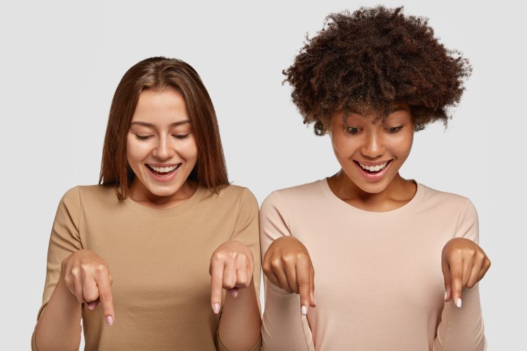 extensa duo deux jeunes femmes métisses décontractées pointent au sol du doigt
