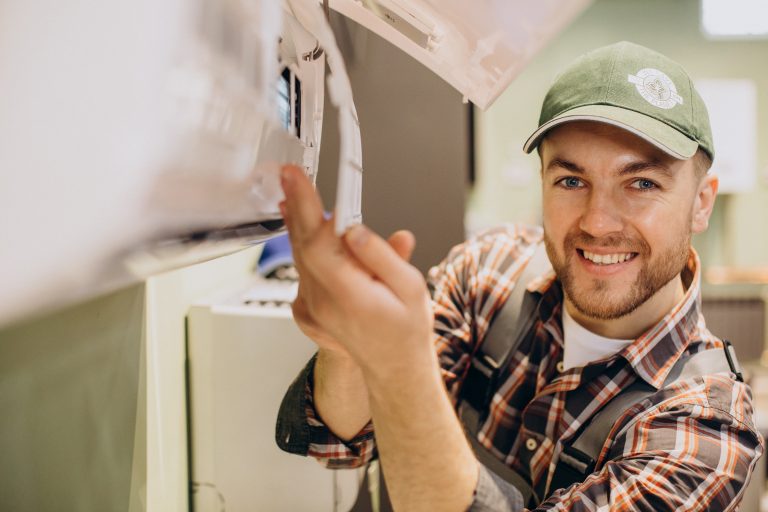 installateur pompe à chaleur en pleine installation ou maintenance d'une unité extérieure