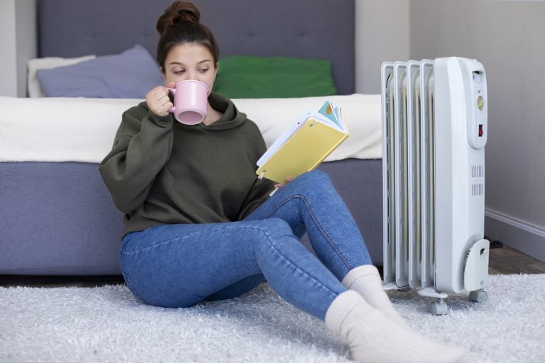p0mpe a chaleur air eau une femme lit un livre près d’un radiateur, illustrant le confort thermique d’une maison bien chauffée