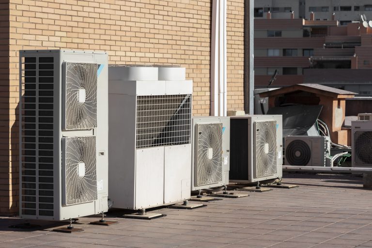 pompe à chaleur immeuble collectif avec unités de climatisation sur la façade d’un immeuble résidentiel en ville