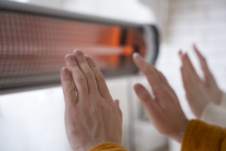 unité de chaleur gros plan sur des personnes se réchauffant les mains près du radiateur